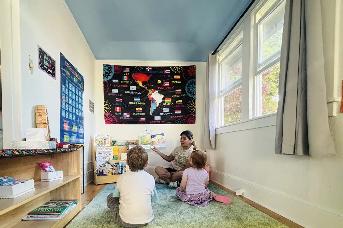 teacher reading a picture book to children during storytime at spanish immersion preschool in albany ca